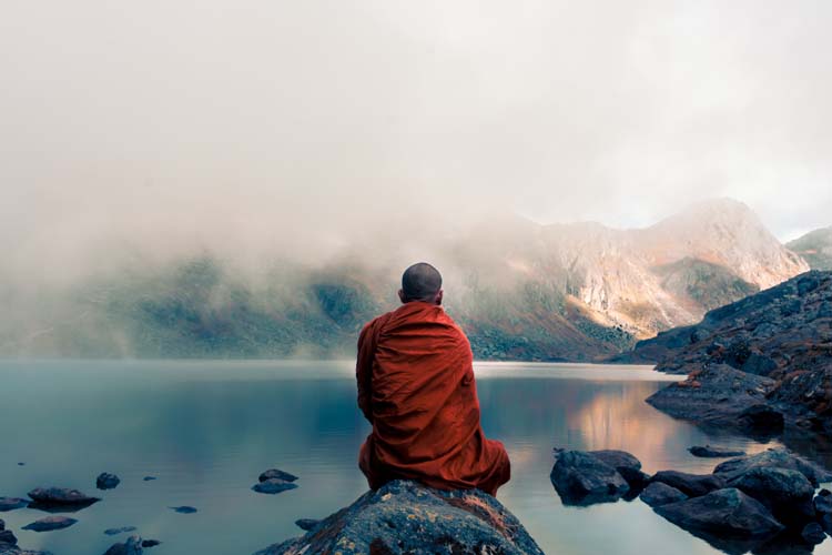 A monk looking at a lake and mountains during a 36-hour fast